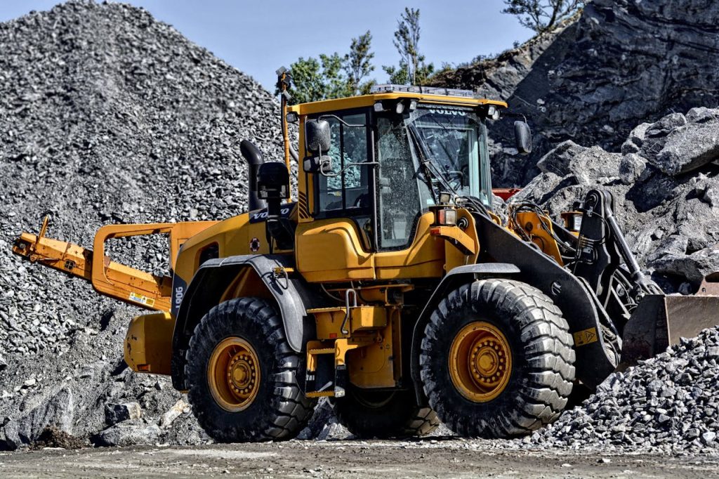 orange-and-black-tractor-next-to-piles-of-rocks-162639 Powerful yellow construction loader moving gravel in an industrial quarry site.